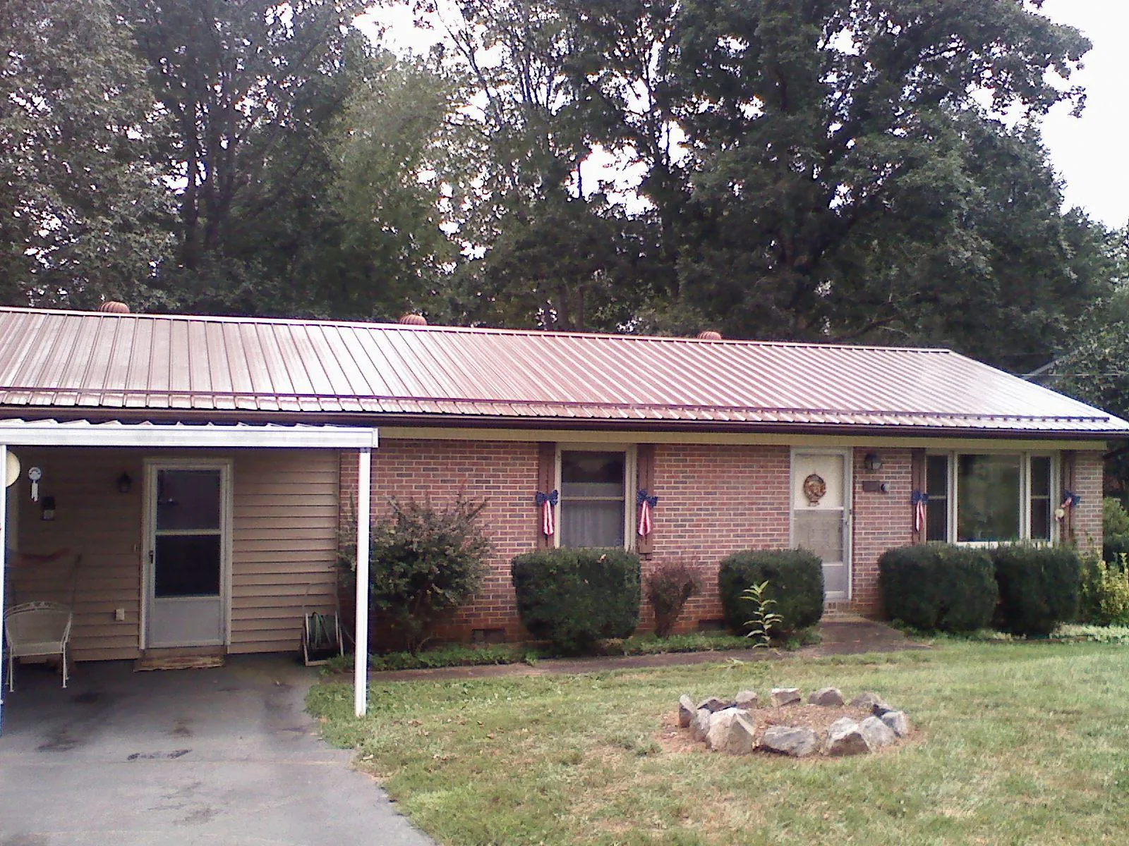 Bronze metal roof and carport on a brick ranch home — Roof Repair work by our crew in Danielsville